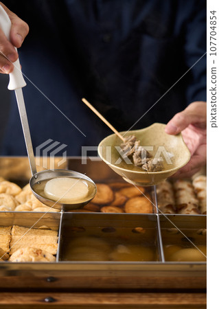 Hot oden - scoop daikon radish with a ladle Hot oden - scoop daikon radish with a ladle 107704854