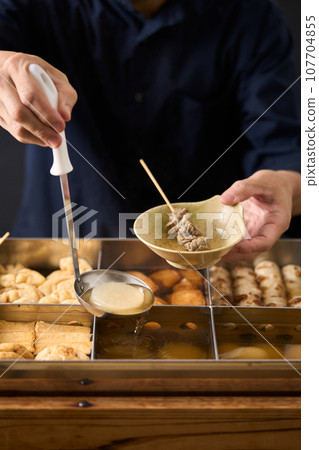 Hot oden - scoop daikon radish with a ladle Hot oden - scoop daikon radish with a ladle 107704855