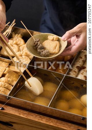 用筷子舀起滾燙的關東煮蘿蔔 107705247