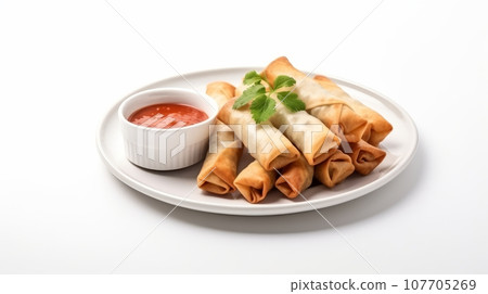 A plate of vegetable spring rolls, accompanied by a dipping sauce.on white background A plate of vegetable spring rolls, accompanied by a dipping sauce.on white background 107705269