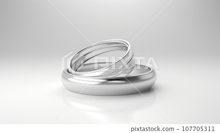 Two silver wedding bands intertwined on a white background. This image symbolizes love, commitment, and marriage. The rings are simple and elegant, reflecting a timeless and classic style. 107705311