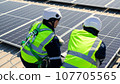 Engineers with safety helmet checking solar system at solar power farm 107705565