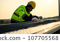 Engineer worker working at solar cell power plant with sunset 107705568