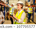 Engineer with safety vest using tablet checking goods on shelves 107705577