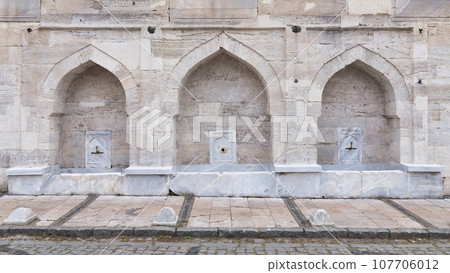 Stone wall of 16th century historic Atik Valide Mosque with row of ablution fountains, Uskudar, Istanbul, Turkey Stone wall of 16th century historic Atik Valide Mosque with row of ablution fountains, Uskudar, Istanbul, Turkey 107706012