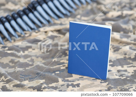 Ukrainian foreign passport on fabric with texture of military pixeled camouflage. Cloth with camo pattern in grey, brown and green pixel shapes and Ukrainian ID 107709066