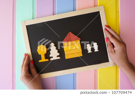 Women's hands lay out figures made of cubes on the board Women's hands lay out figures made of cubes on the board 107709474