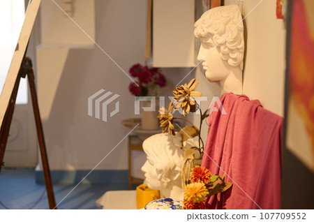 Side view of Apollo plaster head on the desk, displayed for learning drawing in a creative art class or painter workshop Side view of Apollo plaster head on the desk, displayed for learning drawing in a creative art class or painter workshop 107709552