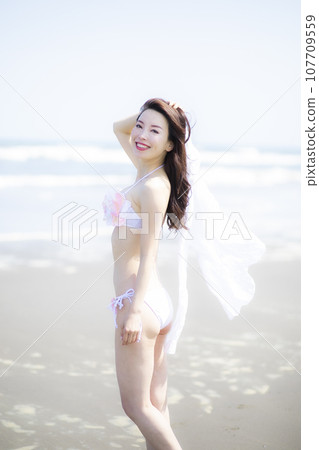 A beautiful lady in a swimsuit came to the sandy shore A beautiful lady in a swimsuit came to the sandy shore 107709559
