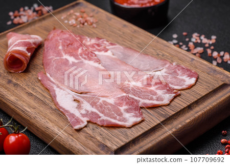 Slices of delicious smoked jamon or prosciutto with salt, spices and herbs 107709692