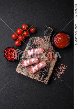 Slices of delicious smoked jamon or prosciutto with salt, spices and herbs 107709701