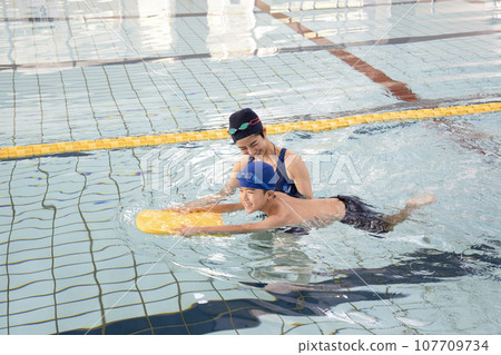 游泳教練教男孩如何在泳池裡游泳 107709734