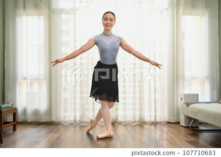 Full length portrait of beautiful woman practicing ballet at home. Dance, art and active lifestyle concept 107710683