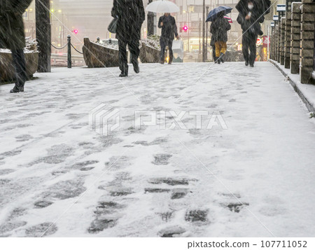 Pedestrians on a snowy day in Tokyo Pedestrians on a snowy day in Tokyo 107711052