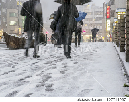 Pedestrians on a snowy day in Tokyo Pedestrians on a snowy day in Tokyo 107711067