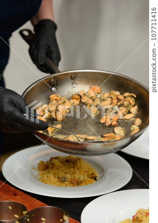 preparation of paella with chicken and mussels 107711416