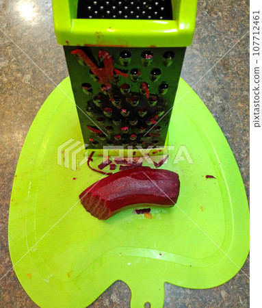 peeled beets and grater on a kitchen board. preparing delicious and healthy food peeled beets and grater on a kitchen board. preparing delicious and healthy food 107712461