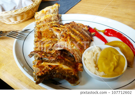 A plate of delicious meat ribs and vegetables. 107712602