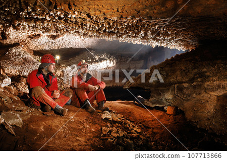 Speleologists exploring a beautiful cave Speleologists exploring a beautiful cave 107713866