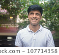 Smart Indian man in white standing outdoors Smart Indian man in white standing outdoors 107714358