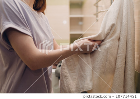 A woman wipes herself with a towel in the bathroom after washing. A woman wipes herself with a towel in the bathroom after washing. 107714451