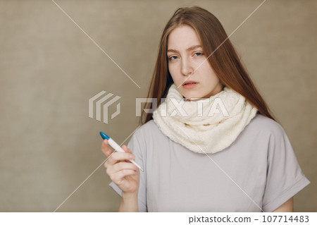 Young woman has autumn flu catarrh ill sick disease treatment cold check measures temperature thermometer 107714483