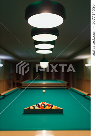 Billiard accessories balls and cue on a billiard table room Billiard accessories balls and cue on a billiard table room 107714550