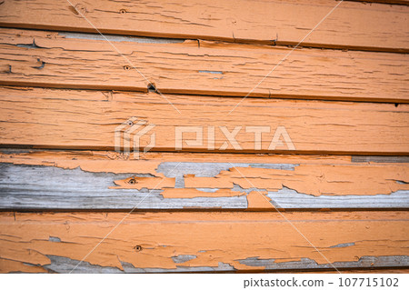Cracked and peeling brown paint. Building facade and exterior 107715102