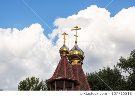 Golden domes of church against background of blue sky Golden domes of church against background of blue sky 107715818