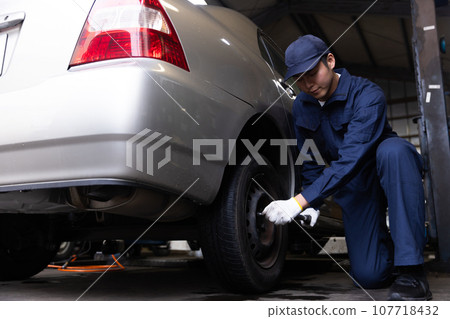 Mechanic inspecting a car Mechanic inspecting a car 107718432