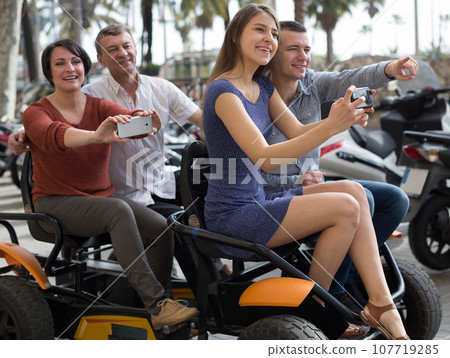 Family of tourists enjoy a walk on the bike carriage 107719285