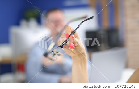 Woman's hand with bright nails holds glasses 107720145