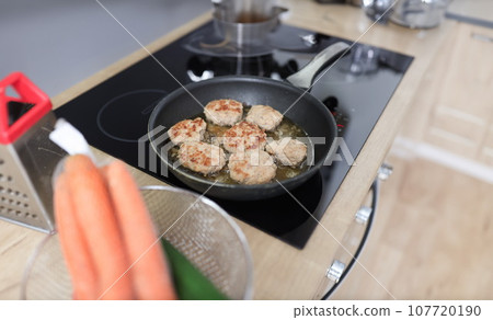 In kitchen, cutlets are fried in frying pan In kitchen, cutlets are fried in frying pan 107720190