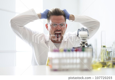 Research assistant looks enthusiastically at microscope closeup Research assistant looks enthusiastically at microscope closeup 107720203