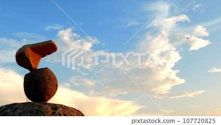 平衡石和夕陽下染成的長頸鹿般的雲彩 平衡石和夕陽下染成的長頸鹿般的雲彩 107720825