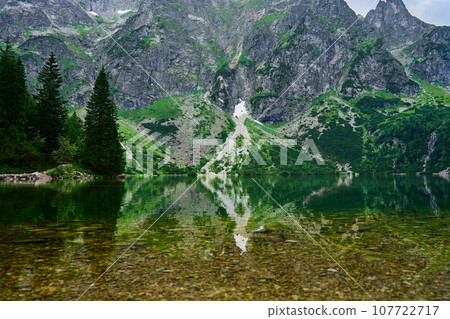Amazing view on mountains range near beautiful lake at summer day. Tatra National Park in Poland. Panoramic view on Morskie Oko or Sea Eye lake in Five lakes valley 107722717