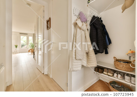 the inside of a house with wooden floors and white walls, there is a coat rack hanging on the wall the inside of a house with wooden floors and white walls, there is a coat rack hanging on the wall 107723945