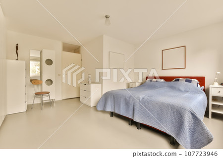 a bedroom with a bed, dresser and mirror on the wall behind it is a white cabinetd cupboards a bedroom with a bed, dresser and mirror on the wall behind it is a white cabinetd cupboards 107723946