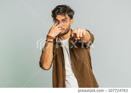 Man pointing at her eyes and camera show I am watching you gesture spying watching on someone 107724763