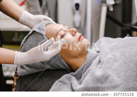 woman needle injection filler for face lifting remove wrinkles in facial spa skin care clinic 107725128