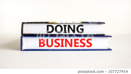 Doing business symbol. Concept words Doing business on beautiful books. Beautiful white table white background. Business, motivational Doing business concept. Copy space. Doing business symbol. Concept words Doing business on beautiful books. Beautiful white table white background. Business, motivational Doing business concept. Copy space. 107727454