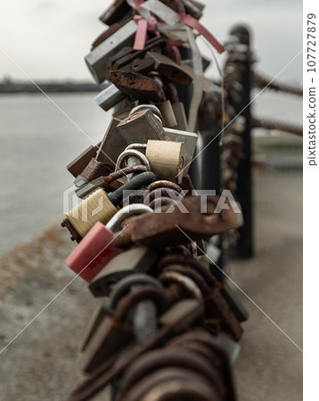 Many love padlocks locked on iron chain with perspective. Many love padlocks locked on iron chain with perspective. 107727879