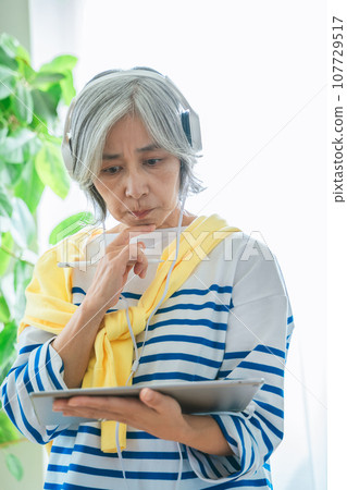 Senior woman with tablet 107729517