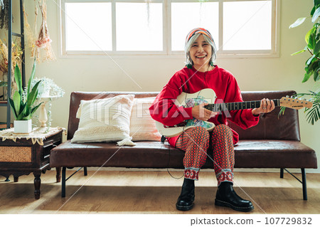 Senior woman enjoying her hobby with guitar in hand 107729832