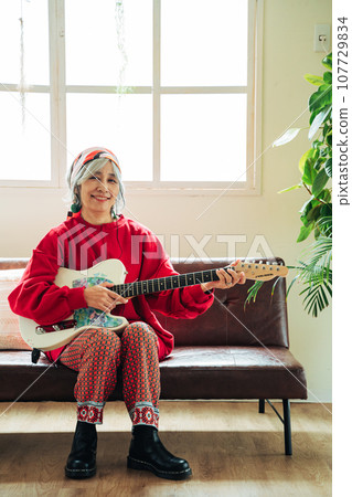 Senior woman enjoying her hobby with guitar in hand 107729834