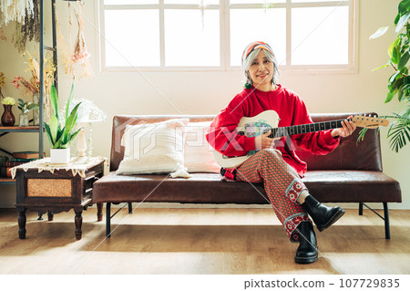 老婦人手裡拿著吉他享受著她的嗜好 107729835