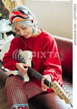 老婦人手裡拿著吉他享受著她的嗜好 107729891
