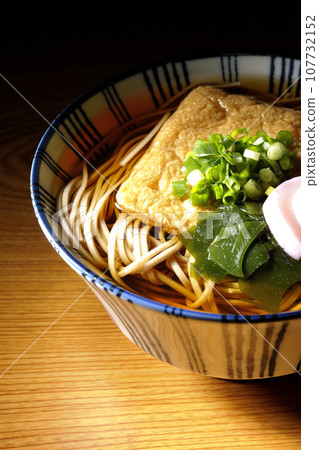 Kitsune soba with fried tofu, kamaboko, wakame, and green onion Kitsune soba with fried tofu, kamaboko, wakame, and green onion 107732152