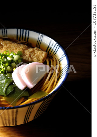 Kitsune soba with fried tofu, kamaboko, wakame, and green onion 107732153