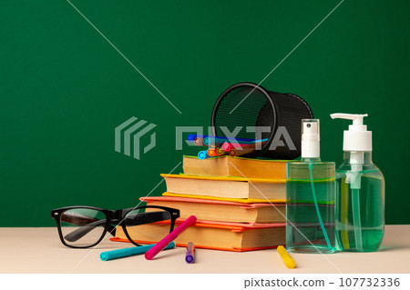 School stationery and hand sanitizer. Back to school concept while coronavirus pandemic School stationery and hand sanitizer. Back to school concept while coronavirus pandemic 107732336